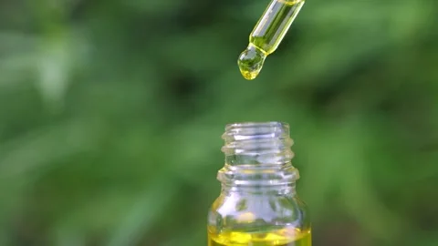 Slow motion of macro close up of droplet dosing a biological, The hemp oil .. Stock Footage 336934145