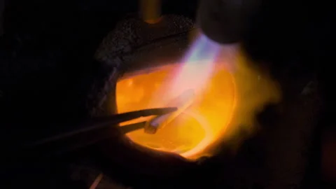 Slow motion macro close up of experienced goldsmith heating a precious metal for Stock Footage 109095896
