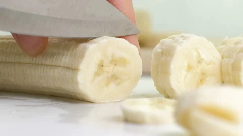 Slow motion macro closeup of chopping fresh banana with knife Stock Footage 88586143
