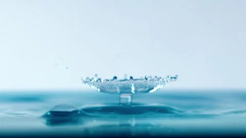 Slow motion macro footage of single water drop hitting surface creating rip.. Stock Footage 337351767