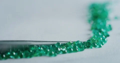Slow motion macro of goldsmith sorting high quality green diamonds. Video stock 114943170