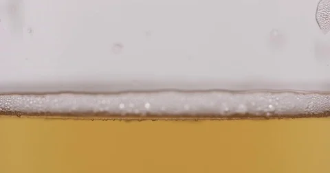 Slow motion macro lager beer pour into glass Stock Footage