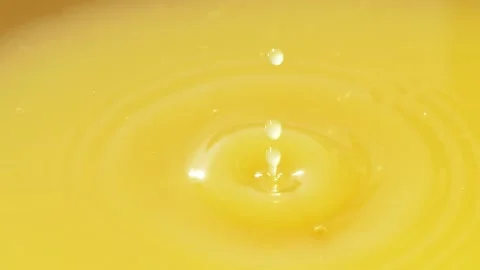 Slow motion of macro orange droplet falling down into fresh orange juice drink Stock Footage 142116579