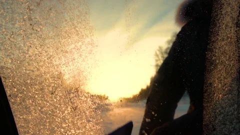 SLOW MOTION MACRO: Removing icy flowers of a frozen car window at winter sunrise Stock Footage 80924504