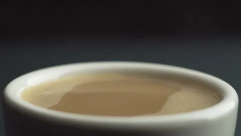 Slow motion macro shot of coffee drop falling from the coffee machine into white Stock Footage 148165044