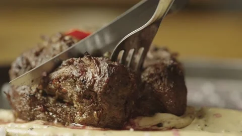 Slow motion macro shot of cutting a steak with a knife in a restaurant. Stock Footage 236901568
