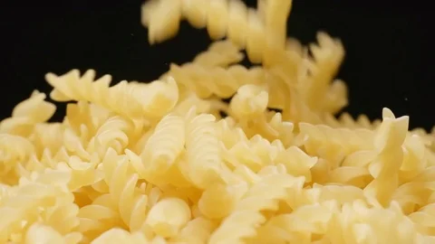 SLOW MOTION: Macro shot of falling of spiral (pasta) on a heap Vídeo Stock 71568472