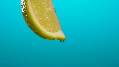 Slow Motion Macro Shot of Flowing Lime Juice from Lime Slice. 4k shot Stock Footage 201341976