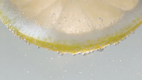 Slow Motion Macro shot of a lemon slice in water bubbles, Drinking Cold Lemonade Stock Footage 203848084