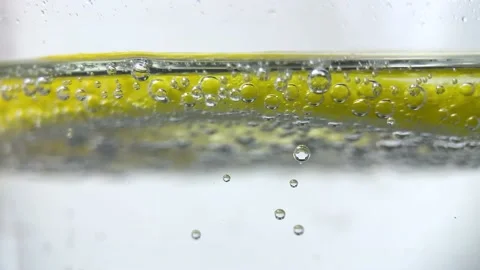 Slow Motion Macro shot of a lemon slice in water bubbles, Soft Drink with Ice Stock Footage 236503214