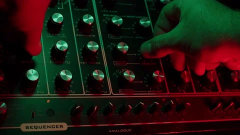 Slow motion macro shot of a man turning knobs on a vintage synth, dark red 動画素材 147237209