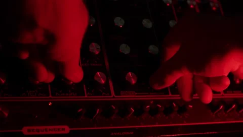 Slow motion macro shot of a man turning knobs on a vintage synth, dark red 動画素材 147237842