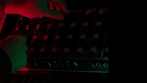 Slow motion, macro shot of a man turnig knobs on vintage synth in a dark 動画素材 147305622