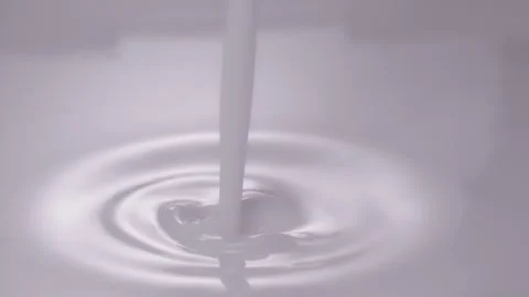 Slow motion, macro shot: Milk pouring into milk. UHD25p Stock Footage 249084557