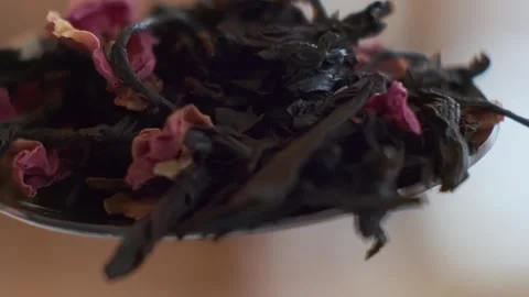 Slow-motion macro shot of spoon with a handful of tea leaves, which are thrown Stock Footage 159582044