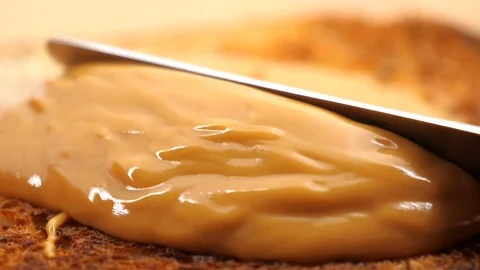Slow motion Macro of spreading creamy peanut butter Vídeos de archivo 85656312
