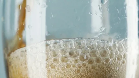 Slow motion macro still life of foamed dark beer poured in transparent glass Stock Footage 78484739