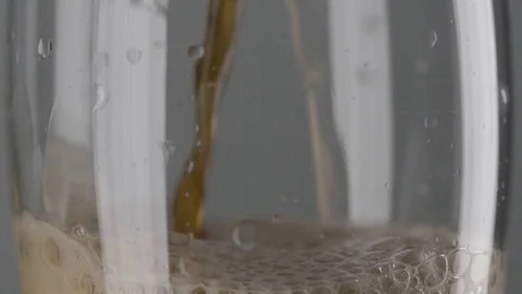 Slow motion macro still life of foamed dark beer poured in transparent glass Stock Footage 78484859