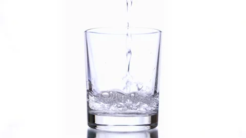 Slow motion macro still life of water poured in transparent glass Stock Footage 154434136