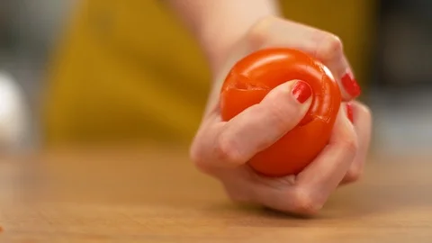 SLOW MOTION, MACRO: Unrecognizable female chef squeezing a ripe organic tomato. Stock Footage 103269453