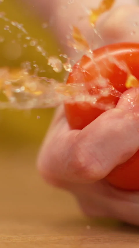 SLOW MOTION, MACRO: Unrecognizable female chef squeezing a ripe organic tomato. Stock Footage 280828660