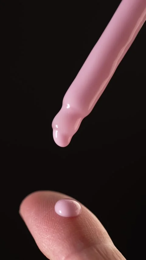 Slow motion macro video of pink creamy serum or lotion dripping from droppe.. Stock Footage 312762761