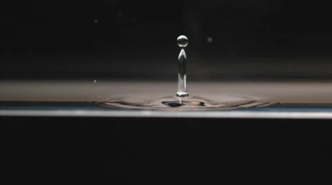 Slow motion macro, water drop falls, splashing and creating concentric ripples Video stock 63828646