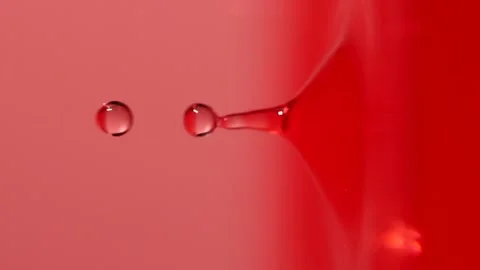 Slow motion of macro water drop falling into pink water, closeup droplet splash Stock Footage 197451565
