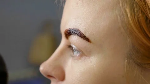 Slow motion of Makeup artist applies paint henna on trimmed eyebrows Stock Footage