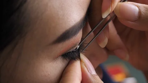 Slow motion, makeup beauty paste long false eyelash on eye Stock Footage 113885523