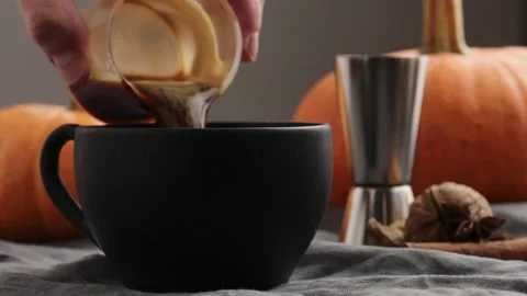 Slow motion making spiced pumpkin latte in black cup, pour espresso Stock Footage 347998386