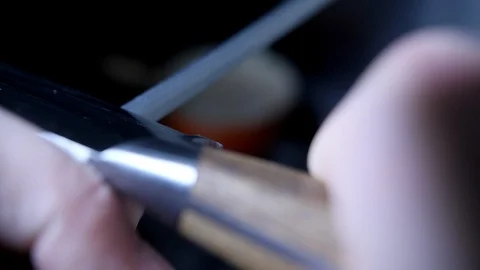 Slow motion - Male Chef sharpening knife with honing steel sharpener Stock Footage 86541096