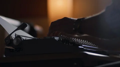 Slow motion of a man adjusting the paper in an old vintage typewriter with dust  Stock Footage 97873668