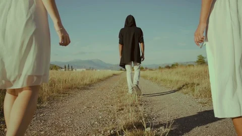 Slow Motion! A man and two girls are on a dirt road. Stock Footage 117544849