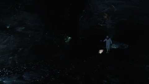 Slow motion - Man in astronaut suit exploring an ice cave, Iceland Stock Footage 104237937