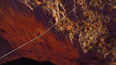 Slow motion with a man athlete slacklining , highlining above a big canyon . Stock Footage 85260335
