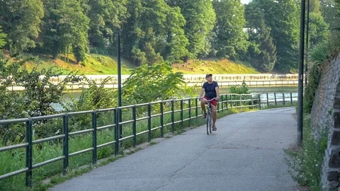 Slow motion of a man that is biking by the river Stock Footage 111729338