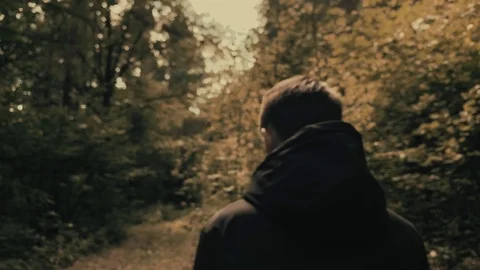 Slow motion . Man in a black jacket walking  in the woods on a sunny day. Stock Footage 113095065