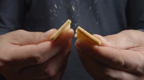 SLOW MOTION: Man breaks a cookie by a hands (close up) Stock Footage 68686962