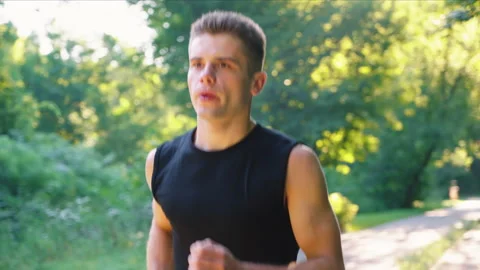 Slow motion man breathing hard while running in park Stock Footage 158533666