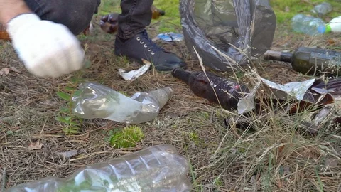 Slow motion man cleans garbage in the woods Vídeos de archivo 115209231