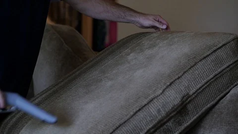Slow motion man cleans green couch cushion with water vacuum  Stock-Footage 85870805