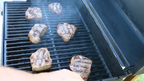 Slow motion man cooks thick steaks for dinner on barbecue Stock Footage 95391198