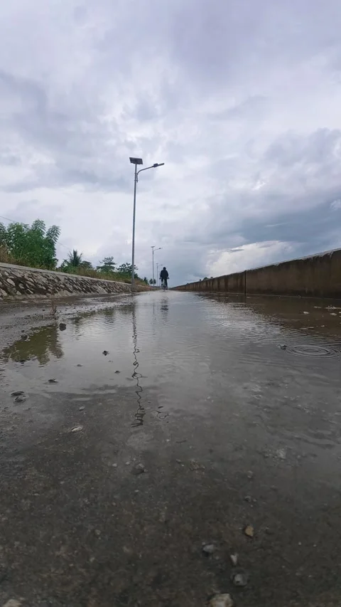Slow Motion of Man Cycling Through Puddles After Rain Stock Footage 333039612