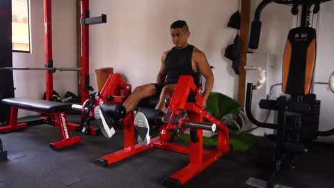 Slow motion of a man doing a leg extension exercise with both feet Video stock 146505776