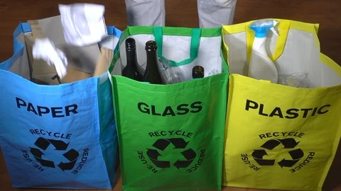 Slow motion – Man dropping paper and plastic bottles into recycle carriers. Video stock 101011035