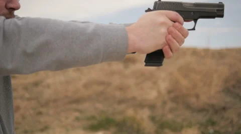 Slow Motion Man Fires Gun Then Admires Shot Stock Footage 60690567