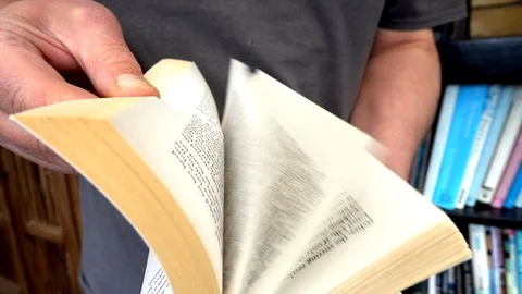Slow motion: Man flicking through the pages of a book. Video stock 89894023