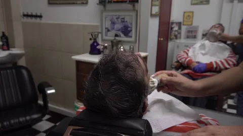 Slow motion of a man getting a shave at a barbershop Stock Footage 141383567