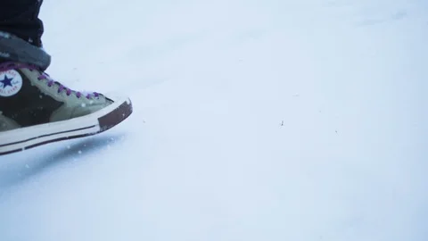 Slow motion. A man goes on deep snow in his converse. Dynamic close up shot Stock Footage 107724498
